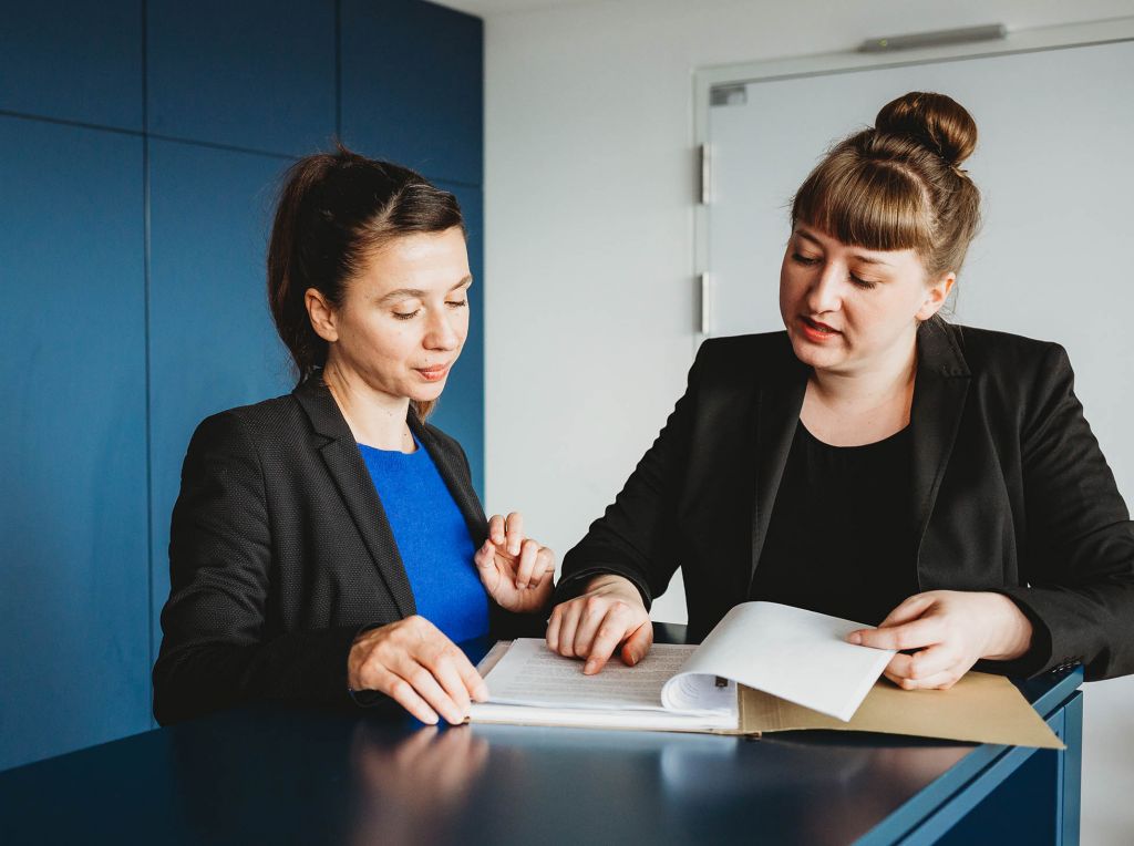 Zwei Fachkräfte diskutieren über ein Dokument – ein wichtiger Moment der Zusammenarbeit und des Austauschs von Expertenwissen.